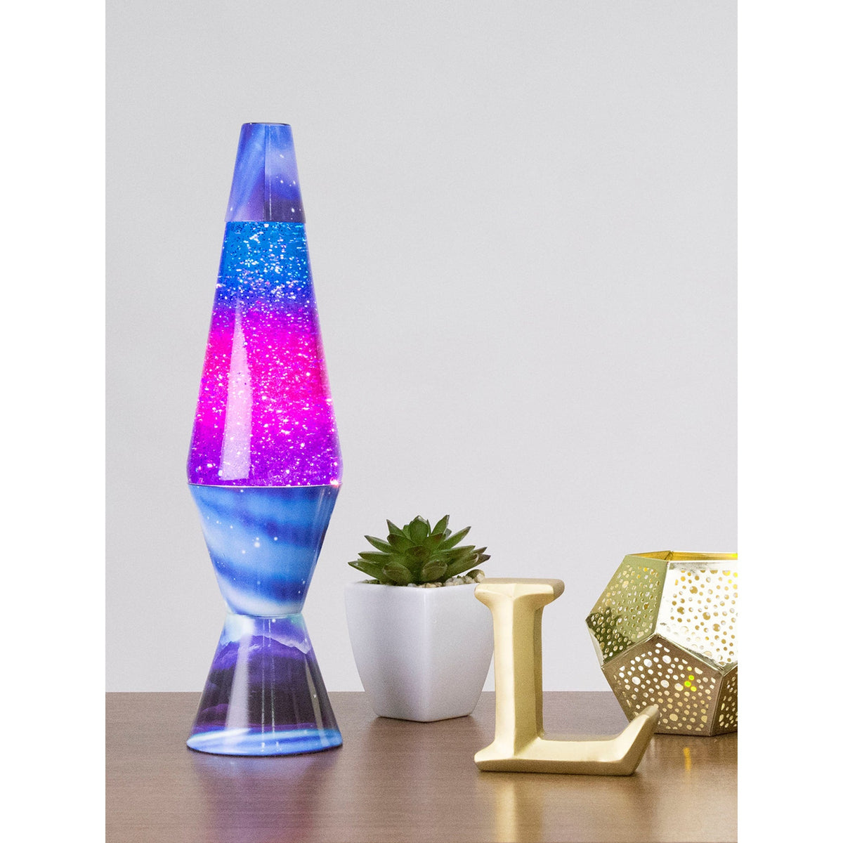 14.5” LAVA® Lamp Colormax Northern Lights – Glitter on a table with a succulent and a candle